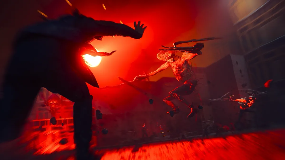 Dylan Faden, seen from behind, throws a glowing paranatural blast at a leaping creature on a red-lit street