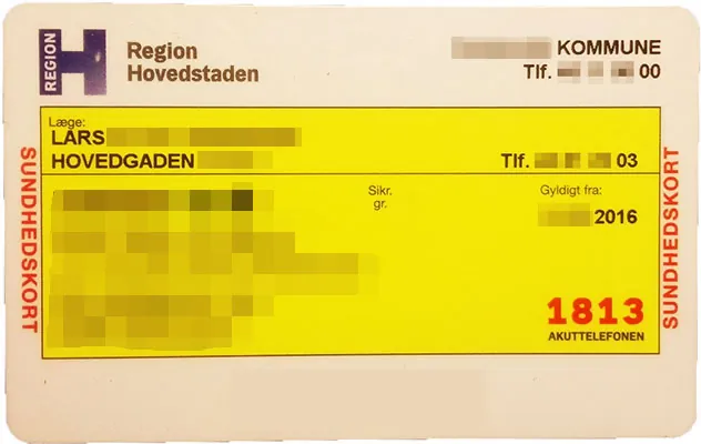 A yellow Danish health insurance card from Region Hovedstaden with the holder's personal details blurred out