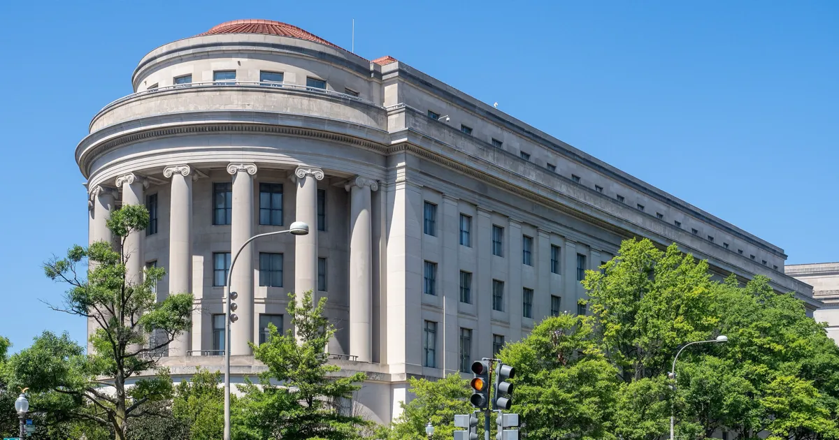 The Apex Building, the Federal Trade Commission's headquarters in Washington, DC, with its rounded colonnade under a clear blue sky