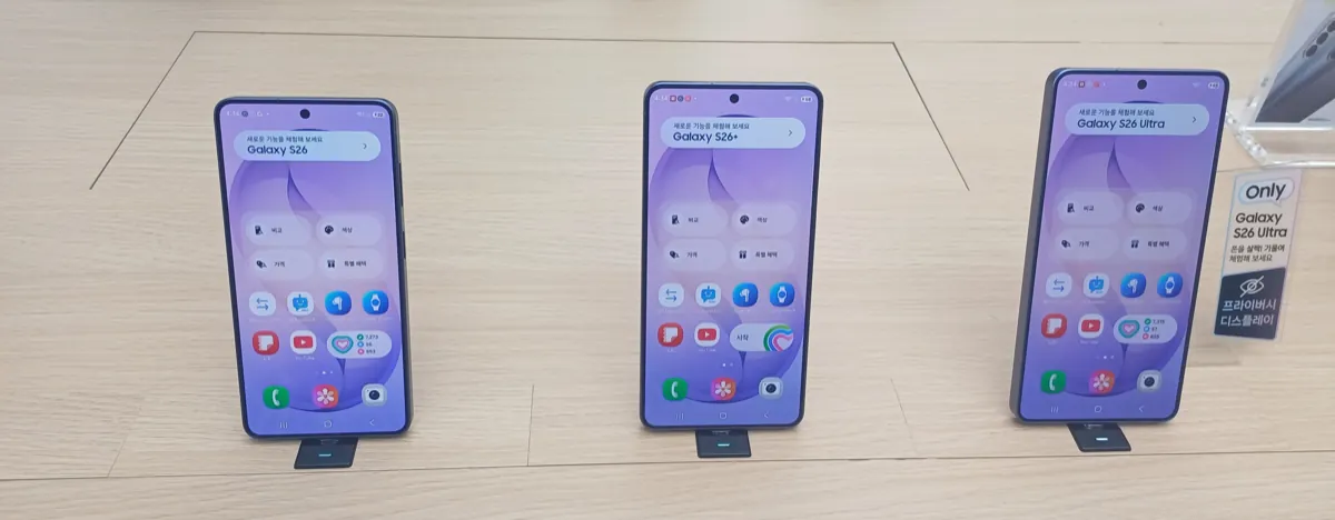 Galaxy S26, Galaxy S26+ and Galaxy S26 Ultra standing side by side on a wooden store display table