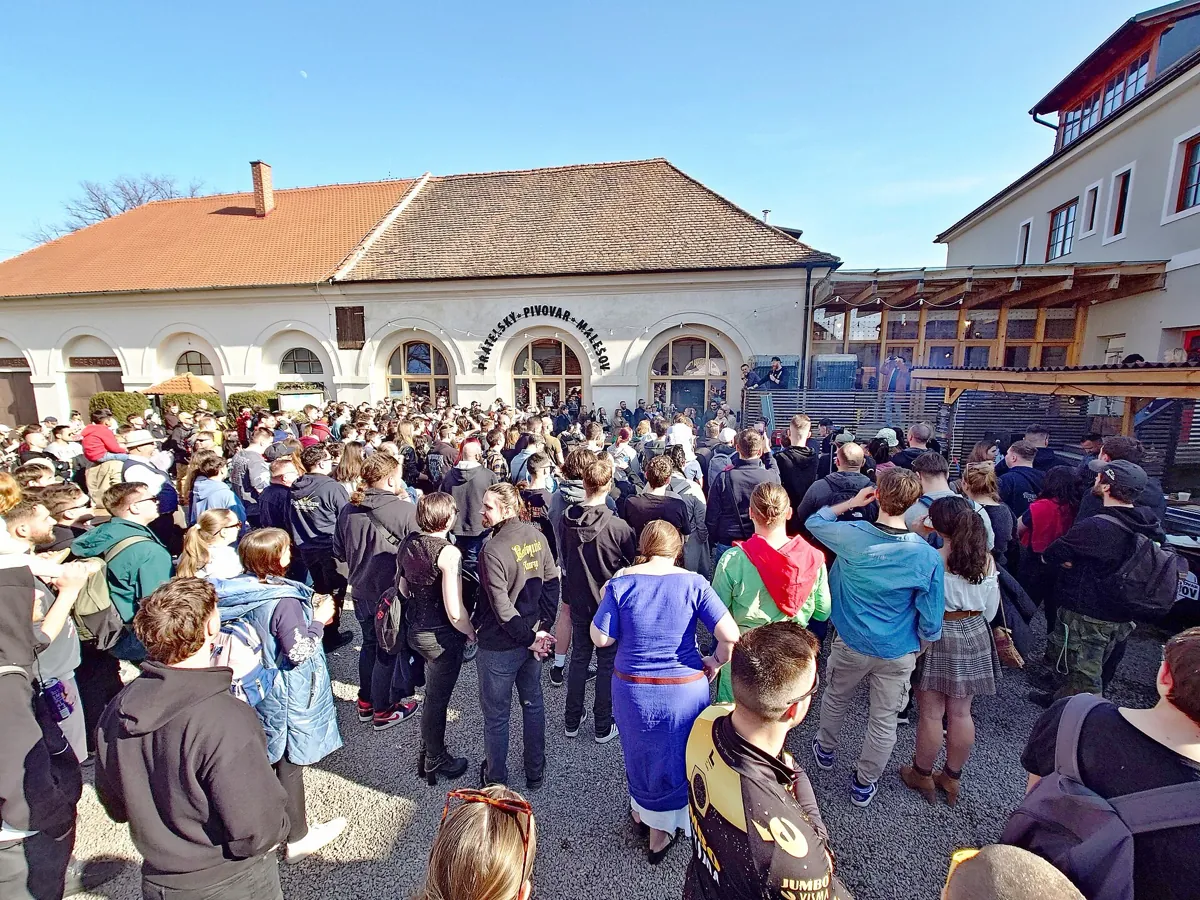A large crowd of fans, some in historical costume, gathered outside a brewery in Malešov, Czech Republic, for a Kingdom Come: Deliverance fan meetup