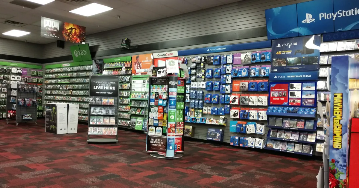 Shelves of PlayStation and Xbox games and accessories inside a GameStop store