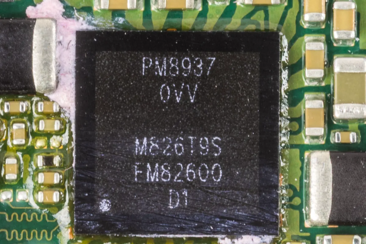 Close-up of a Qualcomm PM8937 chip soldered to the green circuit board of a Huawei Y6 phone