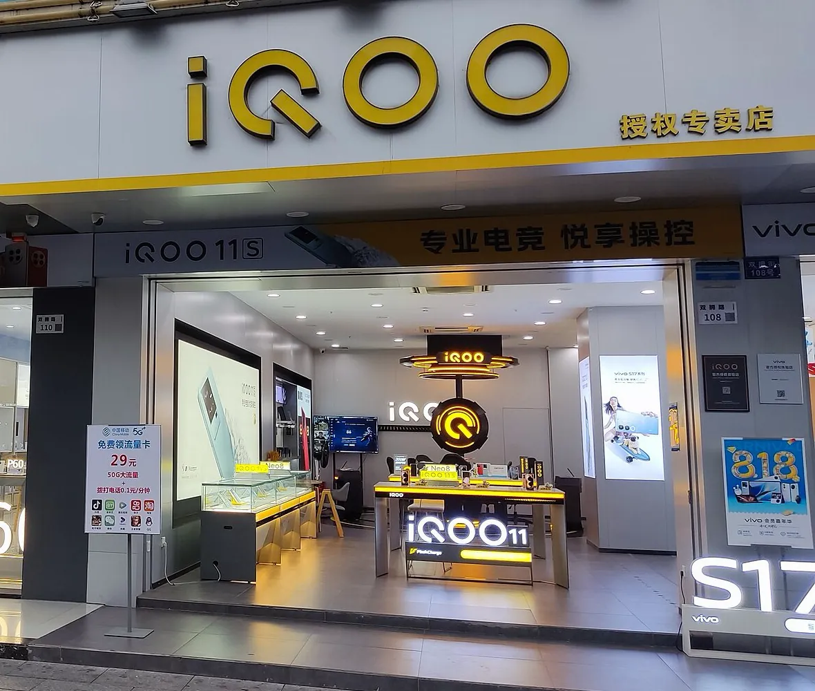Una tienda de celulares de la marca iQOO en Shenzhen, China, con un letrero amarillo de iQOO y celulares en mesas de exhibición