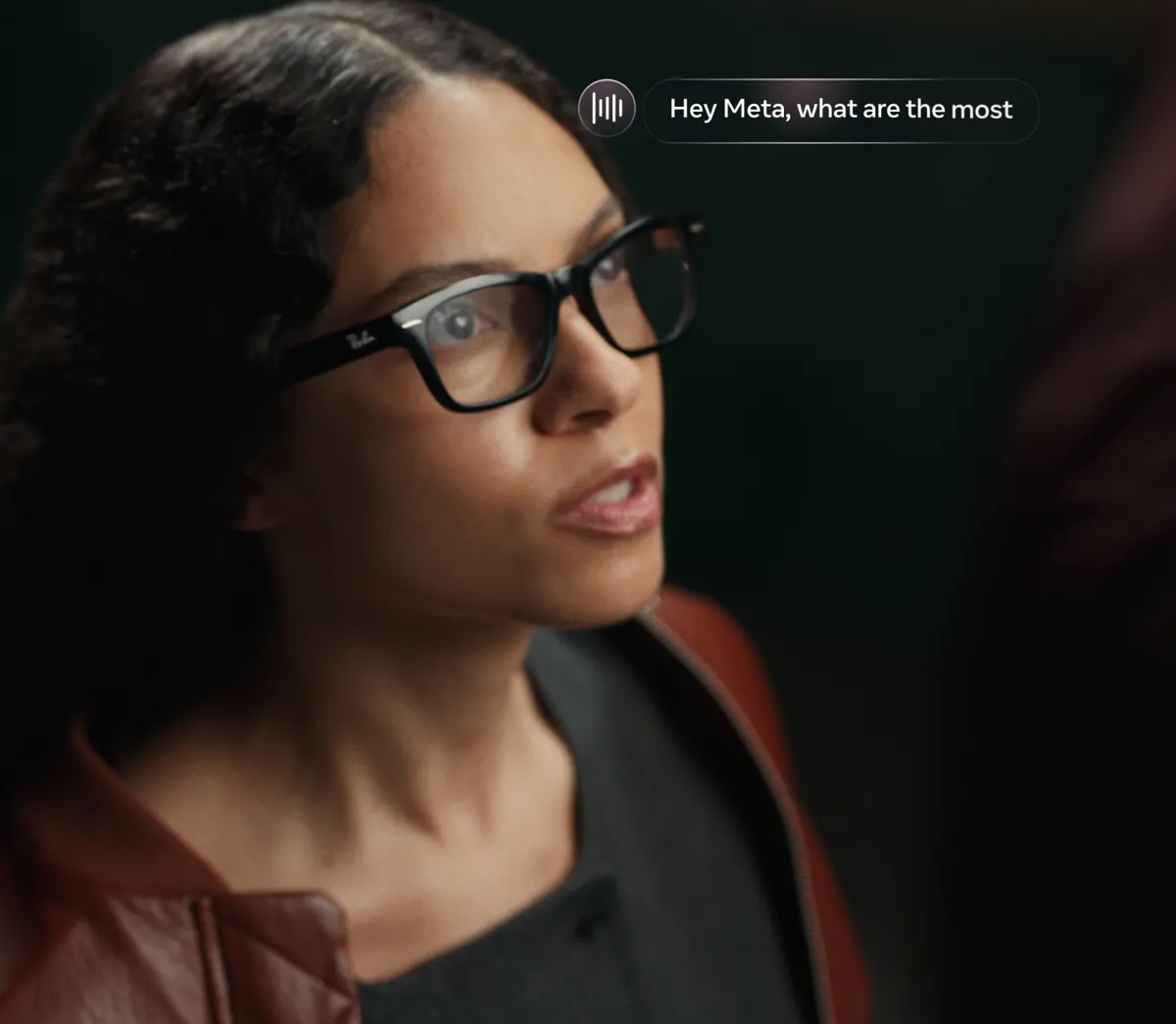 A woman wearing black Ray-Ban glasses asks Meta AI a question, shown as a floating Hey Meta prompt