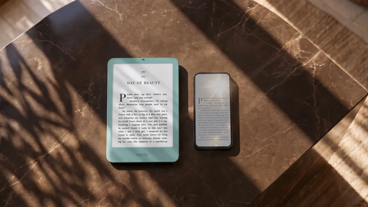 A Kindle Paperwhite in Seaglass Green with a flush-front screen on a marble table next to a smartphone