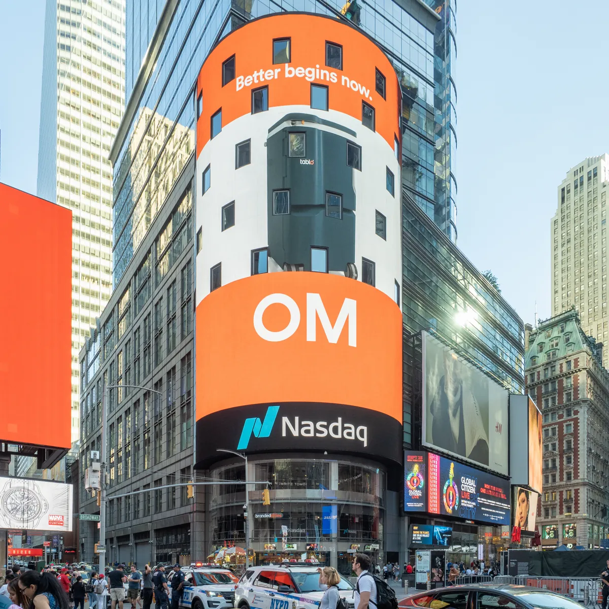 The cylindrical Nasdaq MarketSite tower in Times Square, New York, with an orange digital billboard and the Nasdaq logo above the street