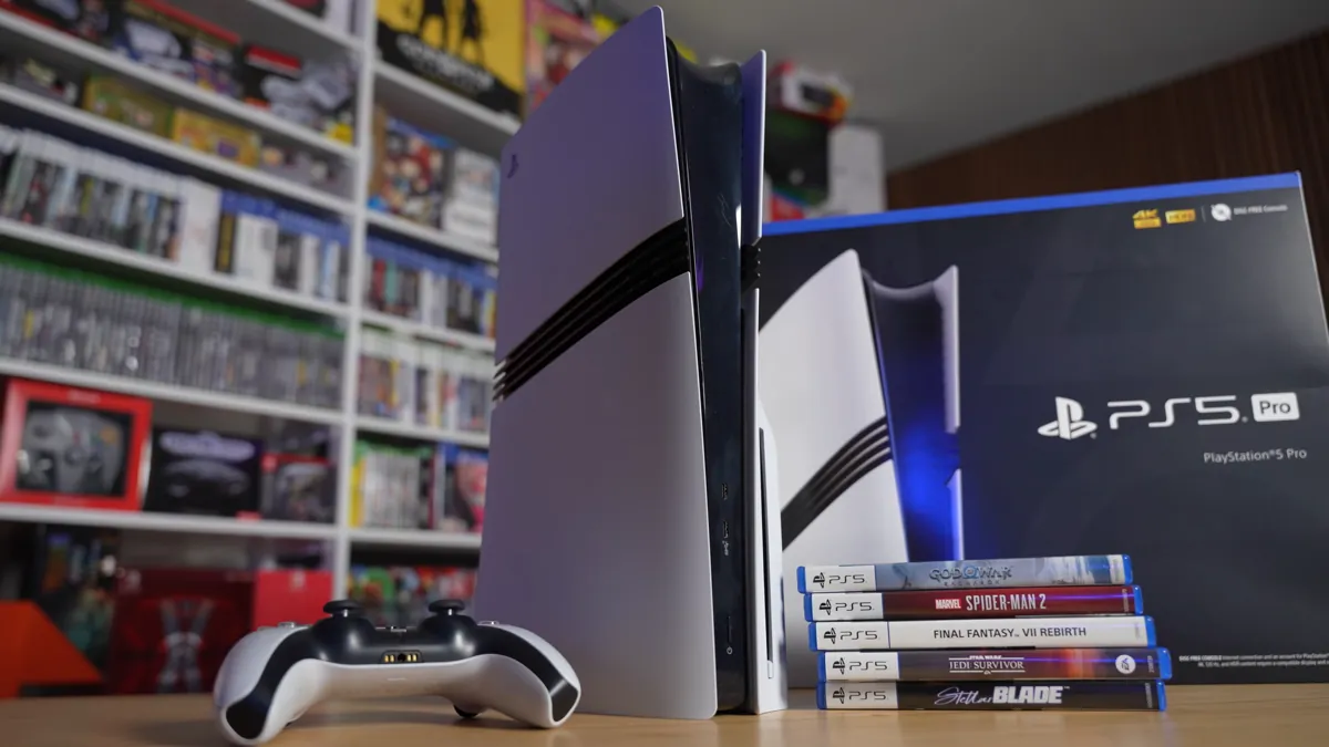A PS5 Pro console beside its retail box, a DualSense controller and a stack of PS5 games