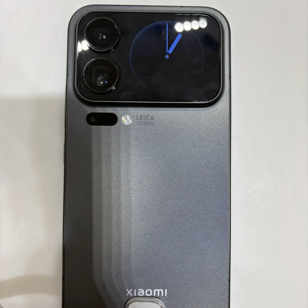 The back of a black Xiaomi 17 Pro Max on a store display, with a small clock screen next to its Leica cameras
