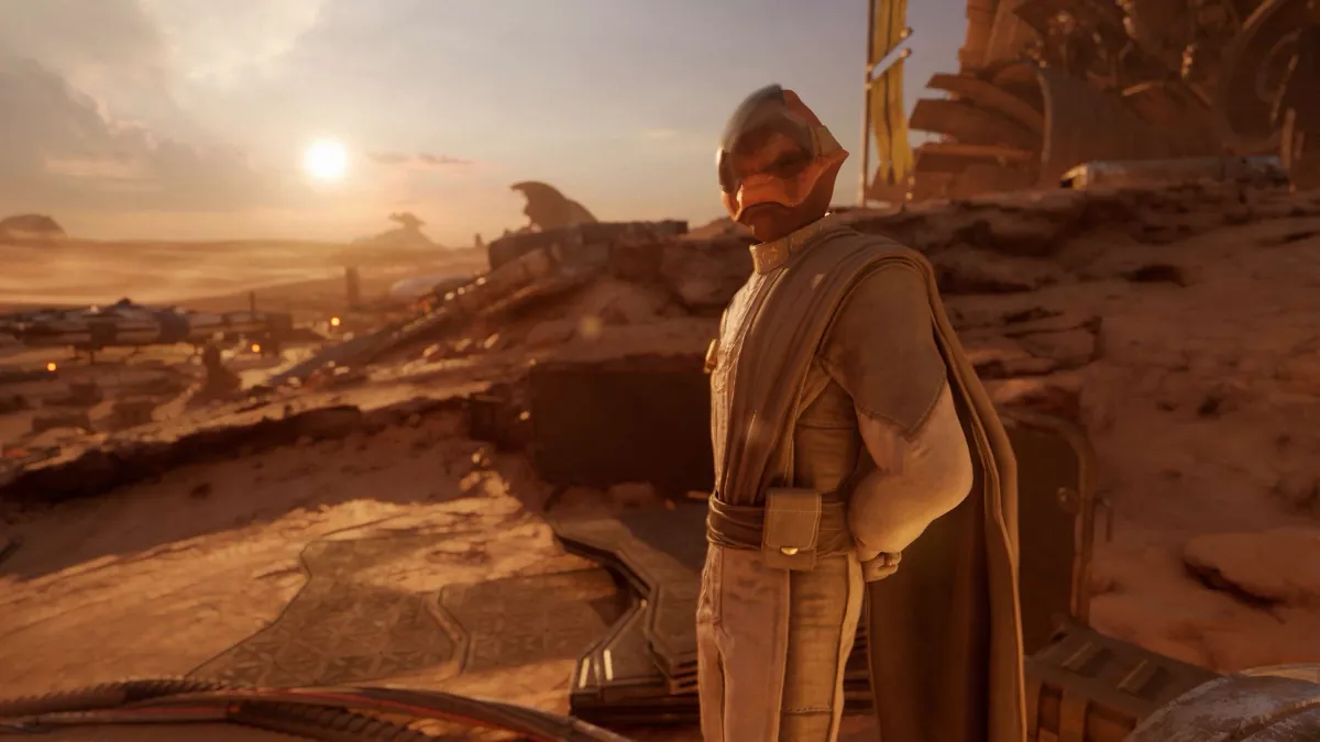 A helmeted alien in a long robe stands on a desert ridge at sunset, overlooking a camp of parked racing speeders