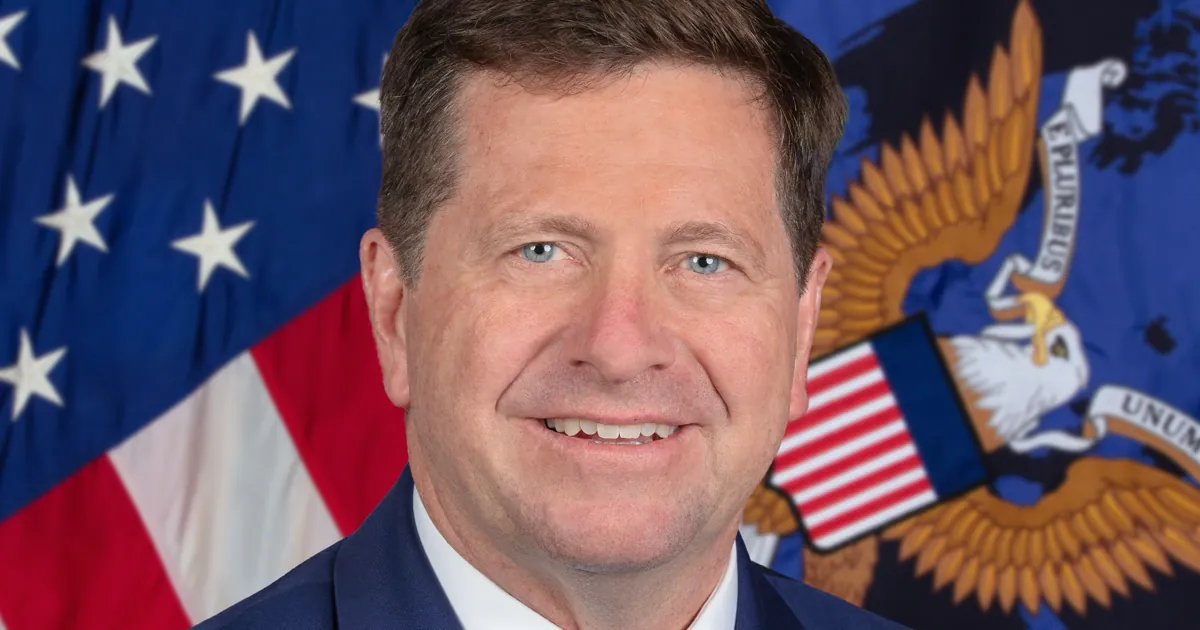 Official portrait of Director of National Intelligence Jay Clayton in front of a US flag and the ODNI seal