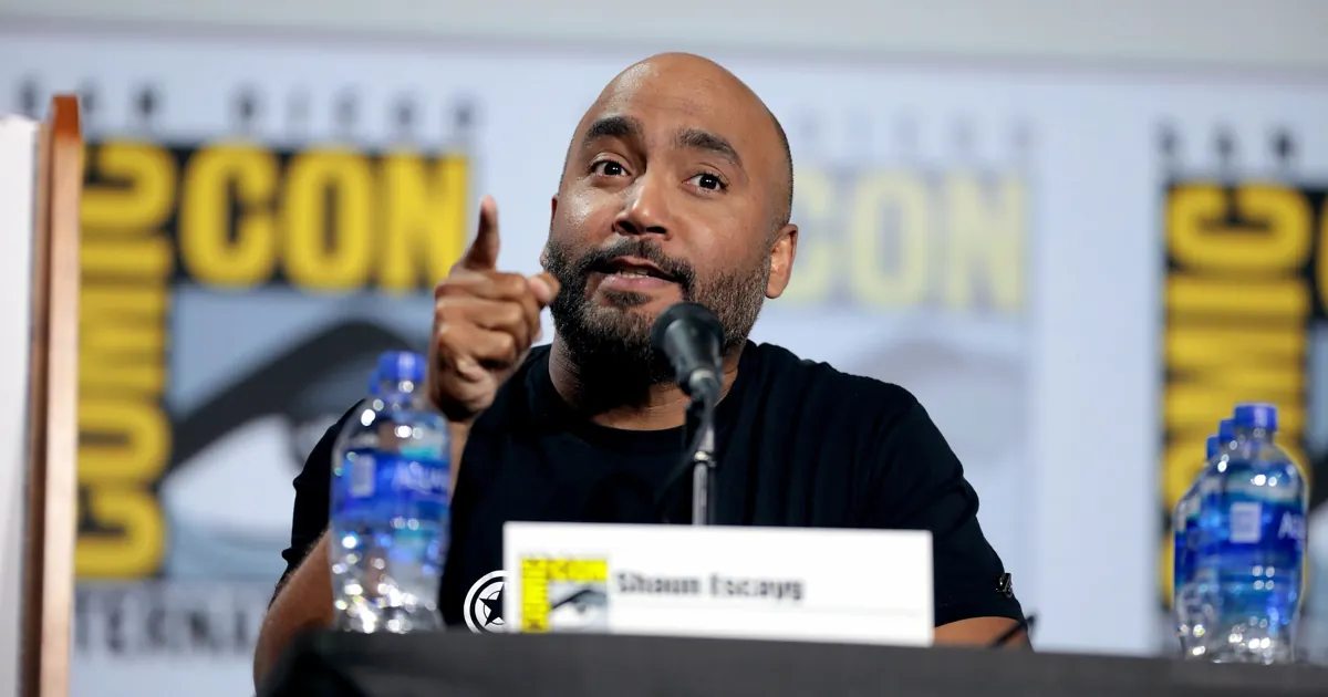 Shaun Escayg, director of Uncharted: The Lost Legacy, speaking into a microphone at a San Diego Comic-Con panel in 2019
