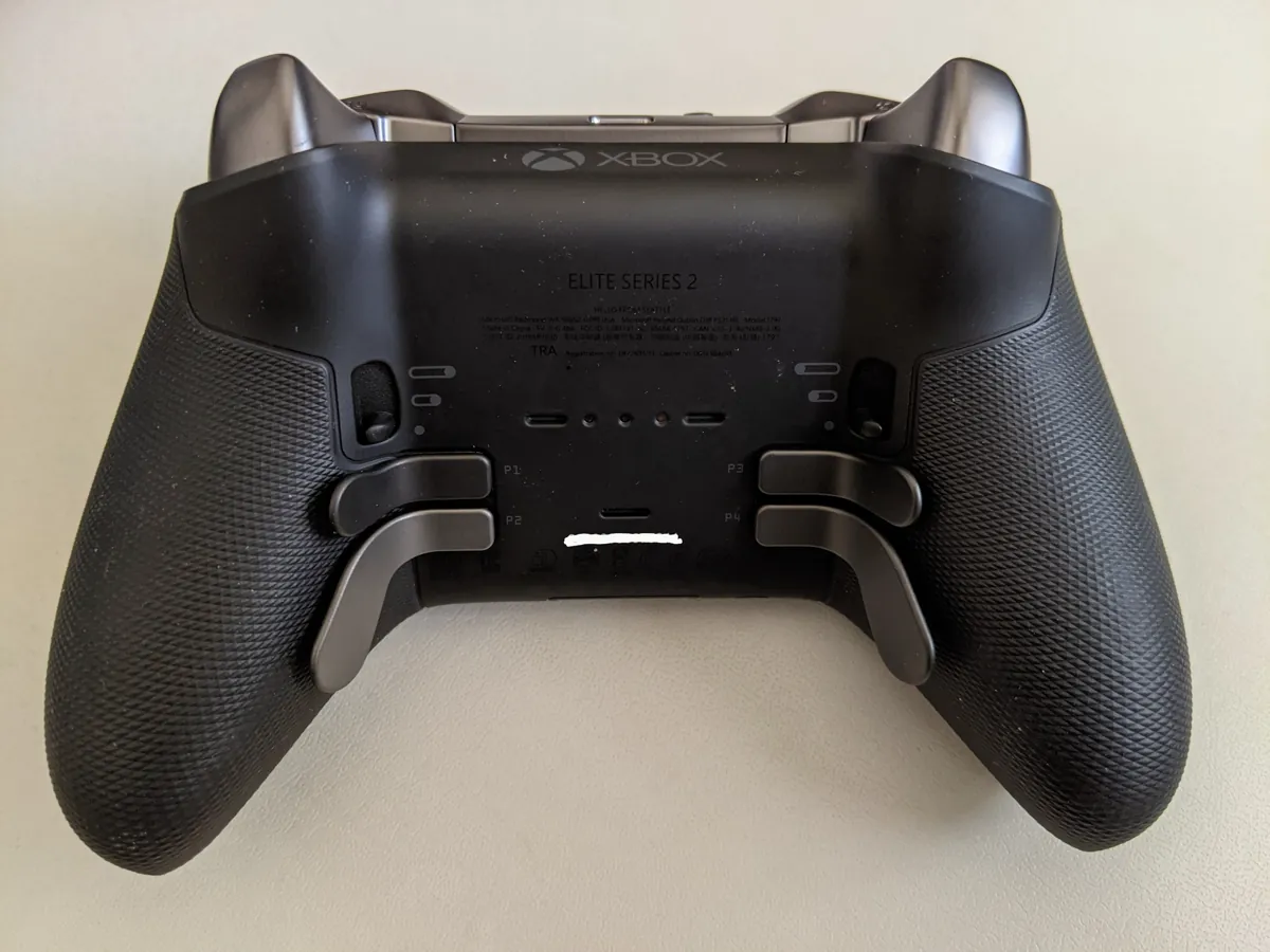 The underside of an Xbox Elite Series 2 controller with its four metal back paddles and trigger lock switches
