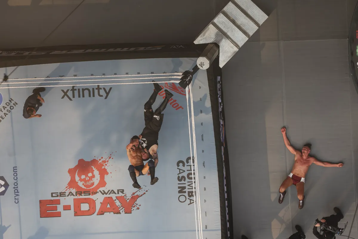 Overhead view of a WWE ring with a Gears of War E-Day logo printed on the mat